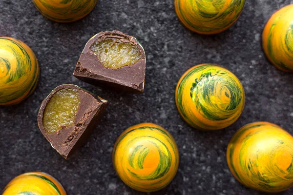 yellow candies in a cut with filling on a stone background