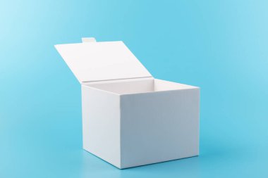 Mavi arka planda beyaz karton kutu açılmış. Tasarım için yer.