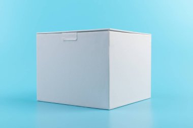 Mavi arka planda beyaz karton kutu açılmış. Tasarım için yer.