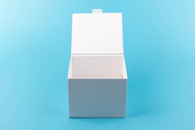 Mavi arka planda beyaz karton kutu açılmış. Tasarım için yer.