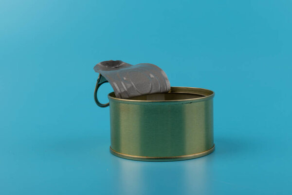Opened pull cap of empty food can, isolated on blue background