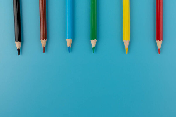 Composition with colored pencils on a bright blue background. top view. space for text.frame
