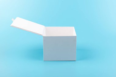 Mavi arka planda beyaz karton kutu açılmış. Tasarım için yer.