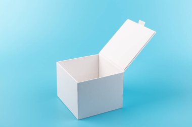 Mavi arka planda beyaz karton kutu açılmış. Tasarım için yer.