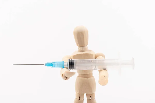 白い背景に対して注射器と木製のマネキン コロナウイルスワクチン テキストのスペース — ストック写真