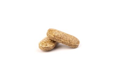 Tıbbi, bitkisel haplar. Besin takviyeleri, beyaz arka planda kahverengi vitamin hapları.
