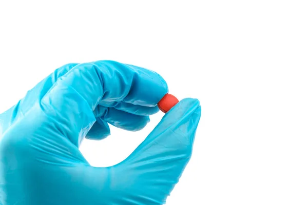 Elinde kırmızı haplar olan eldivenli, elinde haplar tutan tıbbi eldivenli bir doktor.