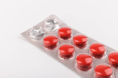 Beyaz arka planda kırmızı haplarla su toplamış. Tıp konsepti