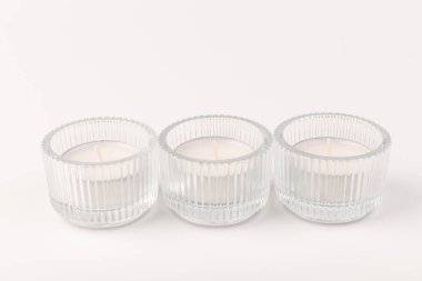 Beyaz arka planda cam tutacağında beyaz mumlar. Çay ışığı.