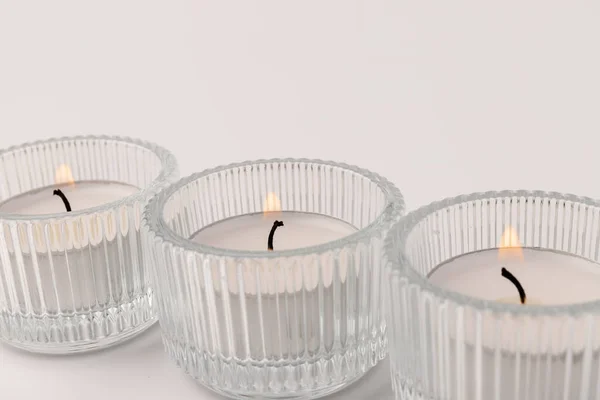 白い上に隔離されたガラスの燭台に小さな燃焼ワックスキャンドル 美しい装飾 — ストック写真