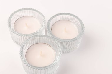 White wax candles in glass holder on white background. Tea light. clipart