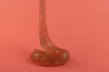 Pembe arka planda parlak balçık. Şeffaf oyuncak. Pembe kız renkleriyle parıltılı desen.