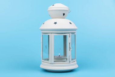 Noel lambası. Mavi arkaplanda eski tarzda beyaz dekoratif fener. 