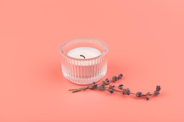 Pembe arka planda mum ve kurutulmuş lavanta yakmak. Ev aromaterapisi.