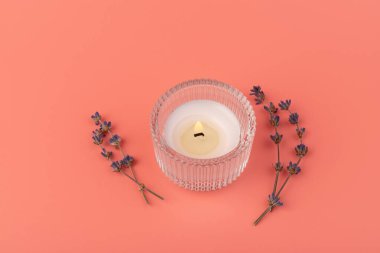 Pembe arka planda mum ve kurutulmuş lavanta yakmak. Ev aromaterapisi.
