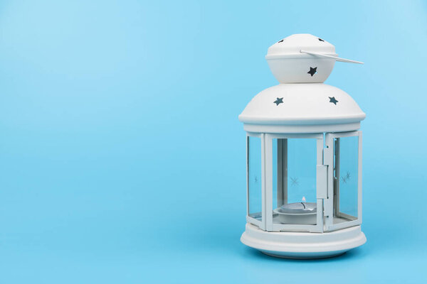 Christmas lamp. White decorative lantern in the old style on blue background. 