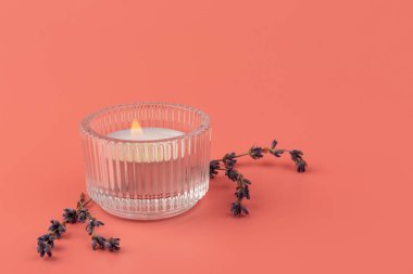 Pembe arka planda mum ve kurutulmuş lavanta yakmak. Ev aromaterapisi.