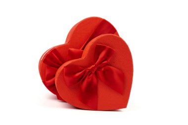 Kırmızı kalp şeklinde hediye kutusu, beyaz arka planda kırmızı kurdele. Sevgililer Günün kutlu olsun. Yıldönümü. 
