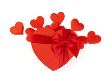 Kırmızı kalp şeklinde hediye kutusu, beyaz arka planda kırmızı kurdele. Sevgililer Günün kutlu olsun. Yıldönümü. 