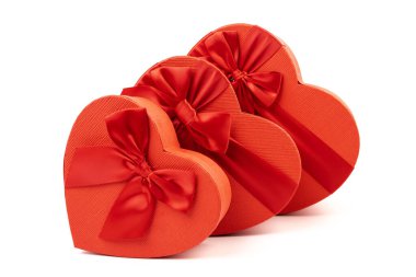 Kırmızı kalp şeklinde hediye kutusu, beyaz arka planda kırmızı kurdele. Sevgililer Günün kutlu olsun. Yıldönümü. 