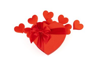 Kırmızı kalp şeklinde hediye kutusu, beyaz arka planda kırmızı kurdele. Sevgililer Günün kutlu olsun. Yıldönümü. 