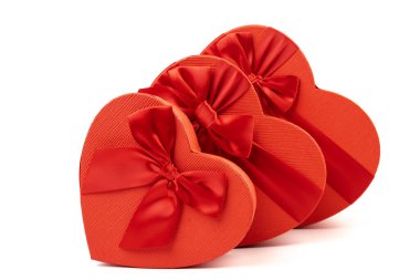 Kırmızı kalp şeklinde hediye kutusu, beyaz arka planda kırmızı kurdele. Sevgililer Günün kutlu olsun. Yıldönümü. 