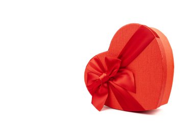 Kırmızı kalp şeklinde hediye kutusu, beyaz arka planda kırmızı kurdele. Sevgililer Günün kutlu olsun. Yıldönümü. 