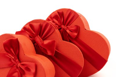 Kırmızı kalp şeklinde hediye kutusu, beyaz arka planda kırmızı kurdele. Sevgililer Günün kutlu olsun. Yıldönümü. 