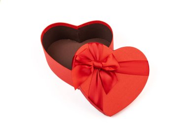 Kırmızı kalp şeklinde hediye kutusu, beyaz arka planda kırmızı kurdele. Sevgililer Günün kutlu olsun. Yıldönümü. 