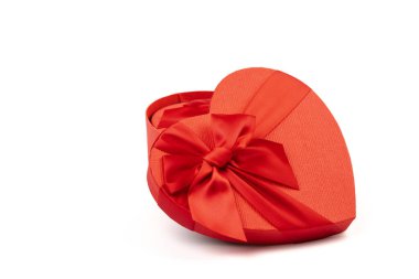 Kırmızı kalp şeklinde hediye kutusu, beyaz arka planda kırmızı kurdele. Sevgililer Günün kutlu olsun. Yıldönümü. 