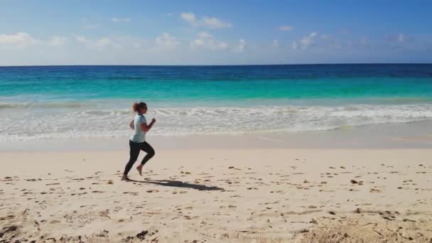 Esportes jogging em férias ao longo da costa do mar — Vídeo de Stock