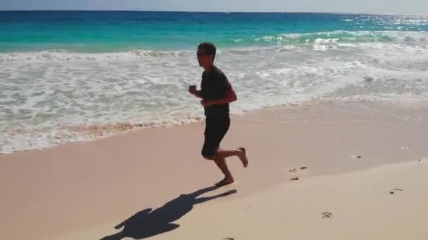 Gesunder Lebensstil junger Mann läuft auf See — Stockvideo