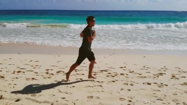 Fit man run along ocean surf by shore, slow motion — Vídeo de Stock