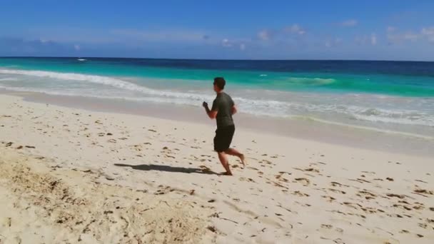 Junger Mann läuft barfuß am Strand, Zeitlupe — Stockvideo