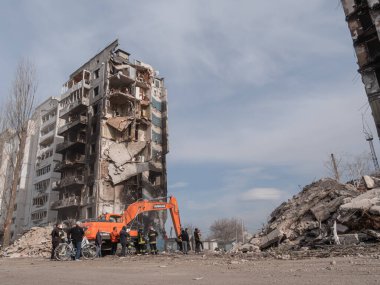 Konut binalarının molozları üzerinde çalışan kazıcı görüntüsü.