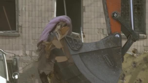 Buldozer odstraňuje trosky při pátrání po lidech zraněných leteckými bombami. — Stock video