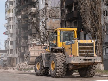 Borodyanka, Ukrayna - Nisan 2022: Buldozer patlama alanından taşınmak üzere inşaat atıklarını kamyona yükledi. Bombalamalarla yaralanan insanları aramak için enkazı temizliyorum. Sivillerin bombalandığı evler.