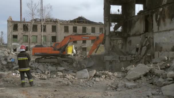 Bulldozer limpia escombros en busca de personas heridas por bombardeos aéreos. — Vídeos de Stock