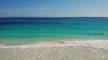 Deniz manzarası. Gök mavisi deniz suyuyla dolu bir sahil. Gün batımında denize doğru ilerliyorlar. Okyanus yüzeyindeki sakin dalgalar. Suyun deniz yüzeyi. Seyahat yaz konsepti. Plajda tatil..