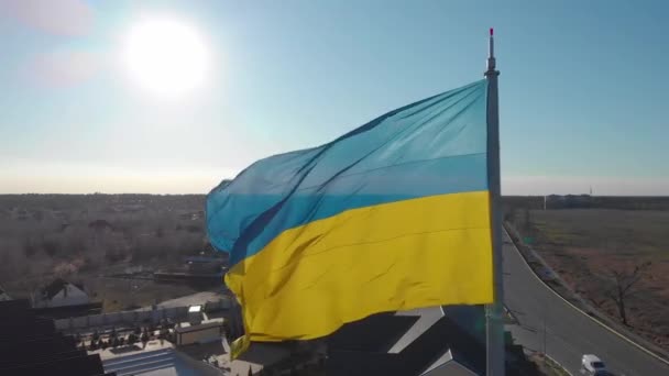 旗竿でのウクライナの旗は 風になびいています ウクライナの旗はロシアのウクライナ侵攻の前に振っている 独立ウクライナの黄青の国旗 太陽の光でウクライナの旗のフラッター — ストック動画