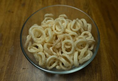 Kızarmış soğan cipsi. Tahtada izole edilmiş kızarmış soğan halkaları.. 