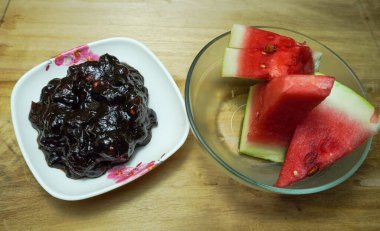 Tahta bir tahtanın üzerinde hintli jube turşusu ve doğranmış karpuz. Yakın çekim yiyecek ve meyveler.. 