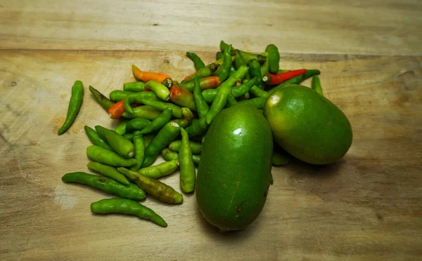 Ahşap bir tahtada yeşil, kırmızı biber ve limonu karıştır. Yakın çekim yiyecek ve meyveler.. 