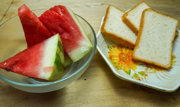 Tahtada ekmek ve doğranmış karpuz. Yakın çekim yiyecek ve meyveler.. 