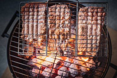 Izgarada kızartılan ya da kavrulmuş taze somonlu ızgaranın ayrıntıları, yukarıdan bakıldığında sıcak kırmızı karbonlar. Canlı ateşte eritilmiş somon balığıyla yapılan mangalın havadan veya tepeden görünüşü