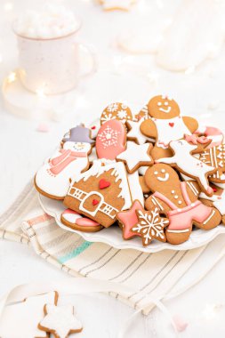 Bir tabak güzel dekore edilmiş parlak ve neşeli zencefilli Noel kurabiyesi..