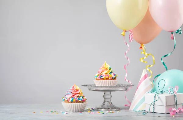 Due Cupcake Compleanno Rainbow Con Regali Cappelli Palloncini Colorati Sfondo — Foto Stock