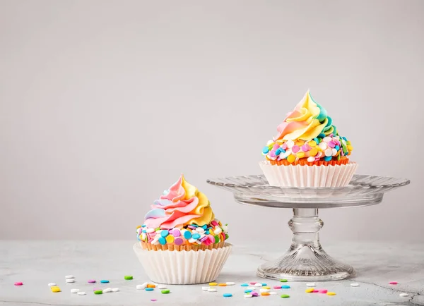 Due Cupcake Compleanno Arcobaleno Con Spruzzi Colorati Sfondo Grigio Chiaro Immagine Stock