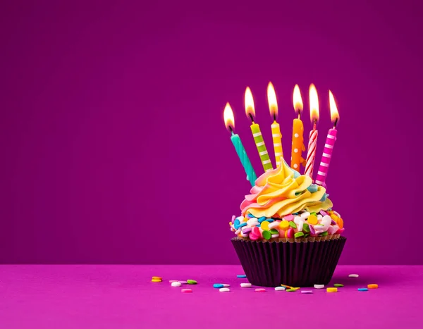 Cupcake Compleanno Arcobaleno Con Sei Candele Compleanno Accese Spruzzi Colorati Foto Stock