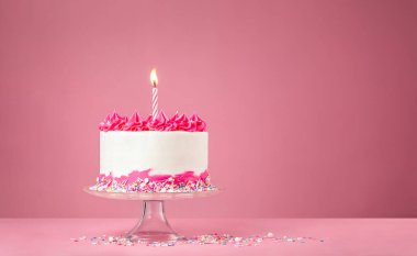 Pembe arkaplanda mum olan Pembe Doğum günü Pastası